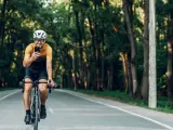 Imagen de archivo de un ciclista usando el móvil mientras pedalea.