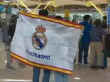 Dos aficionados del Real Madrid en el aeropuerto de Barajas.