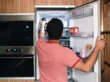 Una persona abre la puerta del frigrífico.