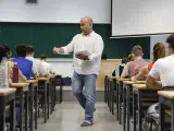 Un docente reparte los exámenes en un aula en Valencia.