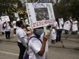 Una trabajadora sostiene un cartel que dice "Alto a la discriminación en el sector maquila" durante una manifestación en el Día Internacional de los Trabajadores el 01 de mayo de 2022 en Ciudad de Guatemala.