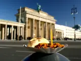 Plato de Currywurst delante de la Puerta de Brandeburgo en Berlín.