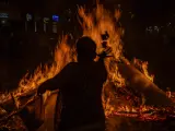 Un hombre tira papeles con sus deseos en la hoguera en la noche de San Juan de 2023, en Barcelona