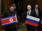 En esta fotografía de grupo distribuida por la agencia estatal rusa Sputnik, el líder de Corea del Norte, Kim Jong Un (izq.), camina junto al presidente ruso, Vladímir Putin, durante una ceremonia de bienvenida a la llegada de Putin a Pyongyang, a primera hora del 19 de junio de 2024.