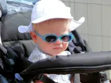 Un niño de paseo en cochecito con gafas de sol.
