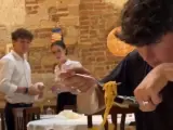 El tiktoker Ben Reid cortando espaguetis delante de unos camareros italianos.
