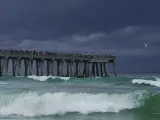 La gente se reúne en el muelle de pesca de Navarre Beach a pesar de que las nubes de tormenta se acercan a la costa en Navarre Beach, Florida, el domingo 16 de junio de 2024.