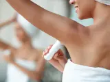 Mujer aplicando desodorante.