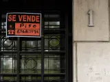 Vista de un cartel de 'Se vende' en un portal de un edificio.