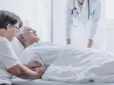 Doctor pronouncing death of an elderly patient in a presence of his spouse