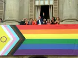 El alcalde de Barcelona, ​​Jaume Collboni, con varios concejales y activistas LGTBI, en el balcón del Ayuntamiento con la bandera del arco iris.