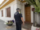 Un agente de la Policía Local en la puerta de la vivienda donde una mujer mató a su padre en Librilla (Murcia).