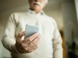 Hombre mayor recibiendo una estafa en su móvil