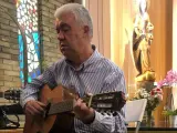 Mariano Fresnillo toca la guitarra en una parroquia.
