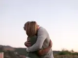 Una pareja abrazándose al aire libre.