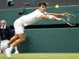 Alcaraz trata de alcanzar una bola durante un partido en Wimbledon.