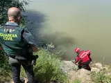 Un Guardia Civil y dos bomberos en el punto del río Ebro donde apareció el cadáver.