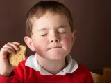 Un niño comiéndose una galleta de chocolate.