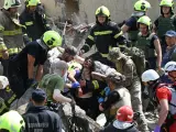 Los equipos de rescate sacan a una mujer herida entre los escombros tras el ataque ruso sobre Kiev.