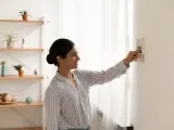 Mujer regulando un termostato