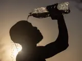 Un hombre refrescándose con agua por el calor.