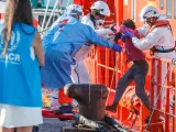 Agentes de salvamento mar&iacute;timo ayudan a una ni&ntilde;a migrante a desembarcar de la guardamar Tal&iacute;a a 25 de agosto de 2021, en Arguinegu&iacute;n (Gran Canaria), Islas Canarias.