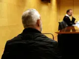 De espaldas, el acusado de prender fuego en casa con los padres dentro de en Sant Antoni de Calonge. Foto del juicio en la Audiencia de Girona.