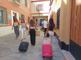 Varios turistas con maletas junto a un alojamiento turístico en el centro de Sevilla