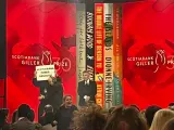 Un protestante sube al escenario de los Premios Giller con un cartel que pone "Scotiabank financia el genocidio".