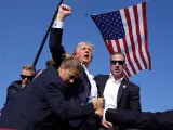 El expresidente de EEUU Donald Trump, alza el pu&ntilde;o tras ser herido en la oreja en un intento de asesinato.