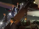 Donald Trump, en el centro de la imagen, bajando de su avión tras el atentado.