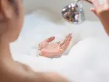 Una mujer dándose un baño relajante.