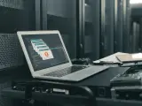 Un portátil con un mensaje de error en la pantalla en una sala de servidores vacía.