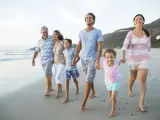 Familia multigeneracional paseando en la playa.