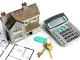 Una maqueta de una casa, unas llaves y una calculadora.