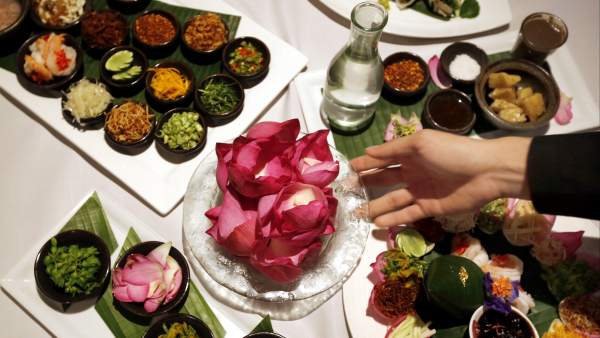A woman places a plate of flowers on a table at the Plaza Athenee-Le Meridien hotel in Bangkok, Thailand.  Thai food is recognized throughout the world for its surprising combinations of sweet, salty, sour and spices, but the least known ingredient in this gastronomy are the flowers that decorate and season many of its dishes.